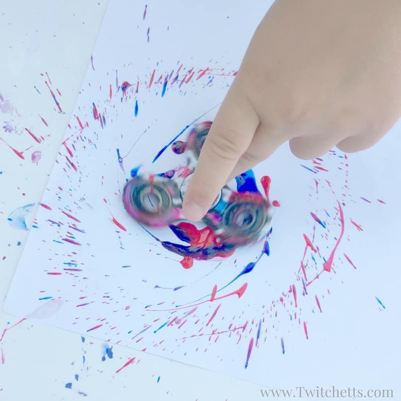 Create this fun firework craft using fidget spinner art. Fidget toys are great for many things, including creating fun paint fireworks that are perfect for the 4th of July! Firework art made from fidget spinners are perfect for Memorial day, Independence Day, or any other time you need patriotic crafts.