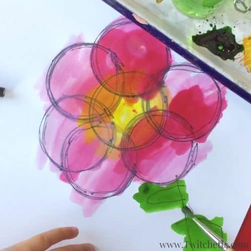 Create fidget spinner art by putting a pen in the hole and drawing circles. Add watercolors to make them vibrant and fun.