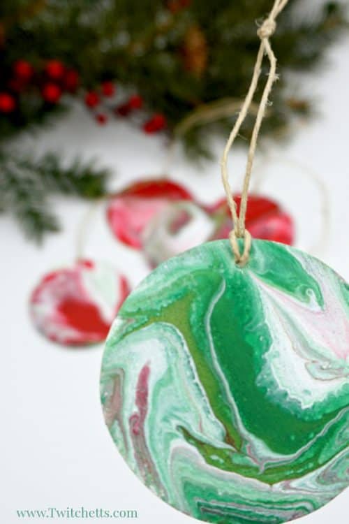 Your kids can create these amazing poured Christmas ornaments. Because pour painting is so unique, each ornament will be unique and amazing! #pourpainting #ornament #christmasornaments #diychristmas #acrylicpour #holiday #woodenornaments #artforkids #twitchetts