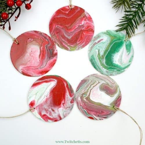 Your kids can create these amazing poured Christmas ornaments. Because pour painting is so unique, each ornament will be unique and amazing! #pourpainting #ornament #christmasornaments #diychristmas #acrylicpour #holiday #woodenornaments #artforkids #twitchetts
