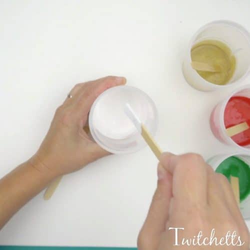Create these beautiful poured Christmas rocks using acrylic paint and an inexpensive thickening agent. Pour painting is a fun process art technique that will mesmerize your kids.