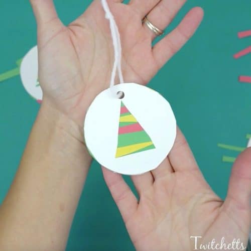This easy paper Christmas tree ornament is a fun paper cutting craft for those preschoolers who are mastering their cutting skills. Grab some construction paper and some kids' scissors let's create! #papertreeornaments #constructionpaper #christmasornaments #christmascrafts #craftsforkids #classroomcraft #giftsfromkids #twitchetts