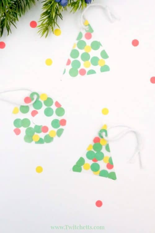 This fun fine motor Christmas ornament uses inexpens-ve construction paper to create a suncatcher that can be given as a gift or hung on your tree. #finemotor #christmasornaments #suncatcher #nomess #easyornaments #preschool #toddler #classroom #twitchetts