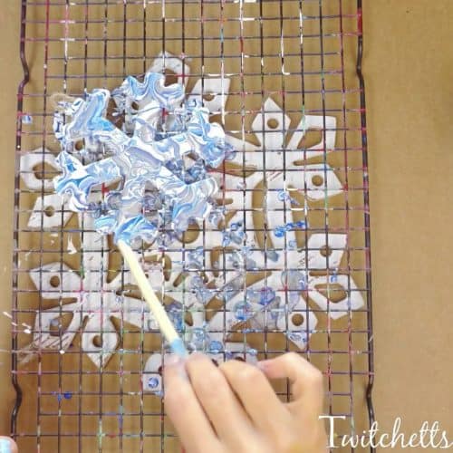 These pour painted snowflake decorations are the perfect winter art project for kids.