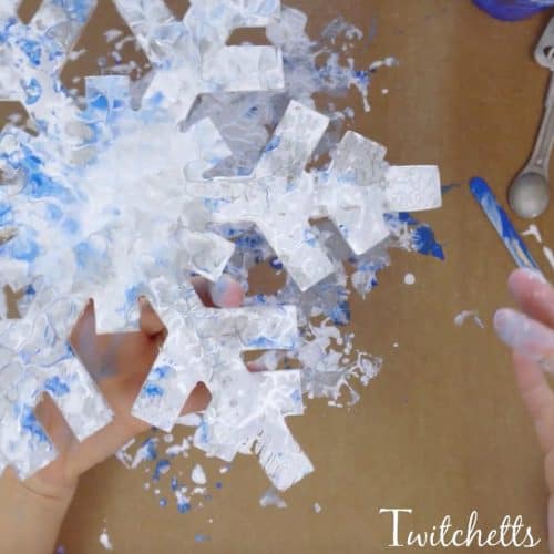 Create press painting snowflake decorations. This creative painting technique is a fun way enjoy painting with kids.