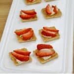 Image of cheesecake bites topped with strawberries. Text reads "4 Ingredient cheesecake bites"