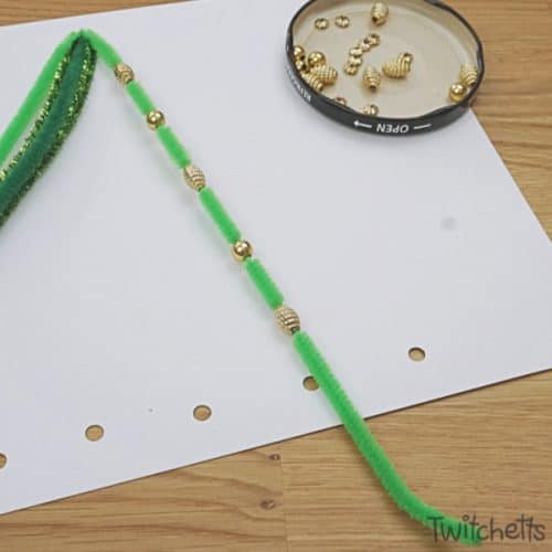 Make this fun pipe cleaner Christmas tree. Sneak fine motor skills into a fun craftivity and you'll end up with a super proud preschooler. #pipecleaner #christmastree #craft #activity #craftivity #preschooler #finemotor #beads #kidscrafts #twitchetts