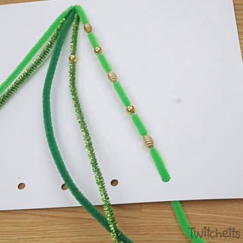 Make this fun pipe cleaner Christmas tree. Sneak fine motor skills into a fun craftivity and you'll end up with a super proud preschooler. #pipecleaner #christmastree #craft #activity #craftivity #preschooler #finemotor #beads #kidscrafts #twitchetts