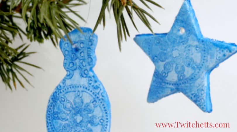 Learn how to make air dry clay Christmas ornaments with this simple and fun tutorial. Grab a cute cookie cutter and a doily to create a beautiful holiday decoration. #airdryclay #christmasornament #holidaydecor #giftideas #ornamentskidscanmake #cookiecutterornaments #craftsforkids #twitchetts