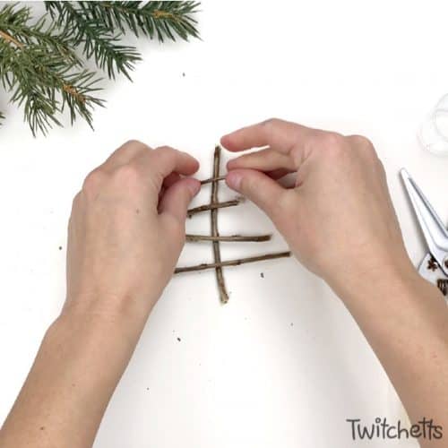 Make sparkly tree-shaped Christmas ornaments using sticks you have laying in your yard. Simple supplies and a Christmas decoration that shimmers. Your kids will be so proud to give these ornaments as gifts.  #nature #christmastree #christmasornament #sparkly #kids #twitchetts