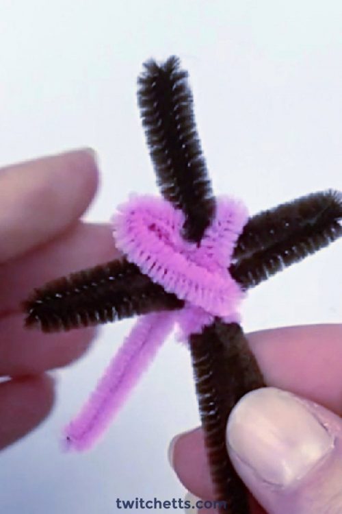Image of a cross pencil topper made with pipe cleaners.
