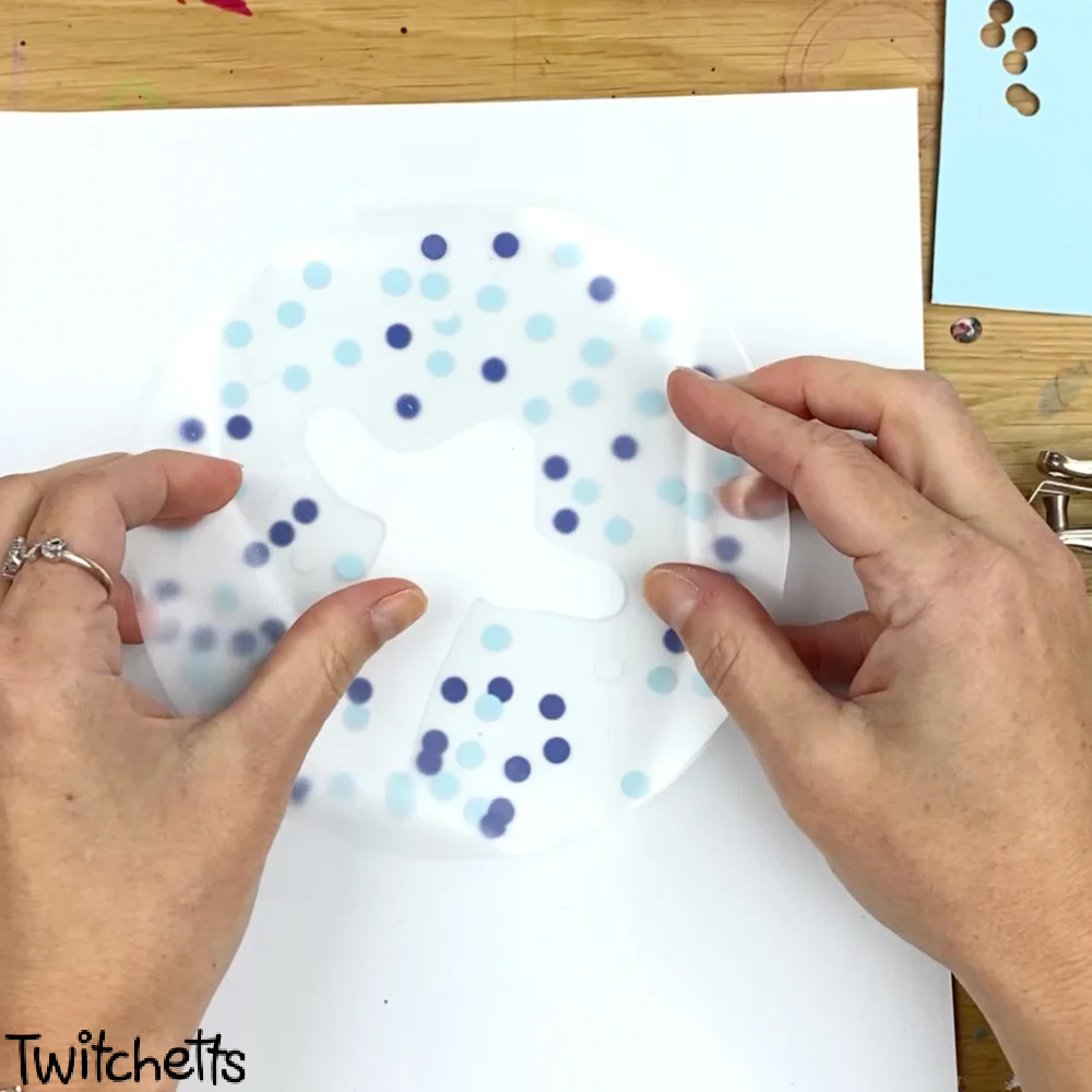 In process image of a paper snow globe craft.