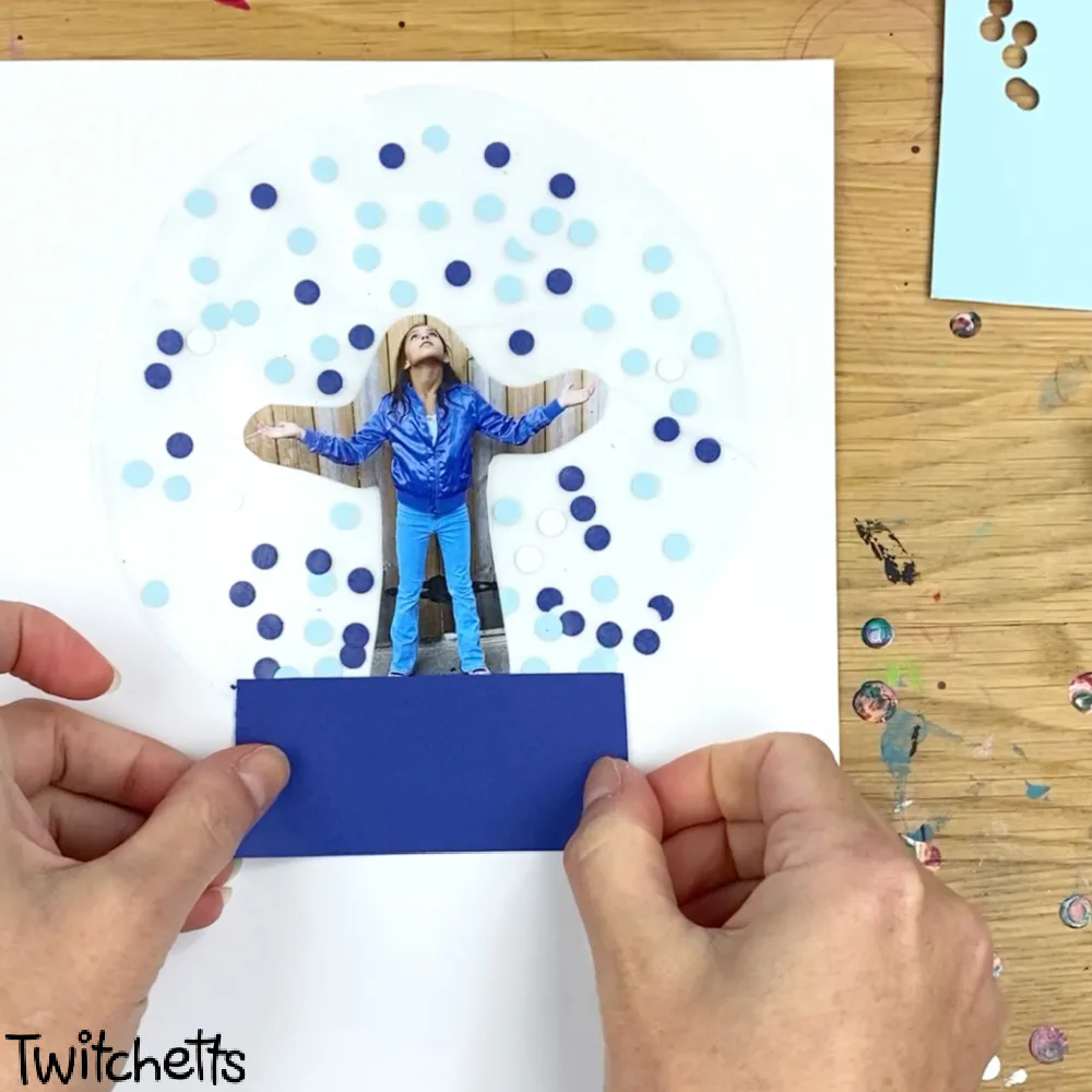 In process image of a paper snow globe craft.