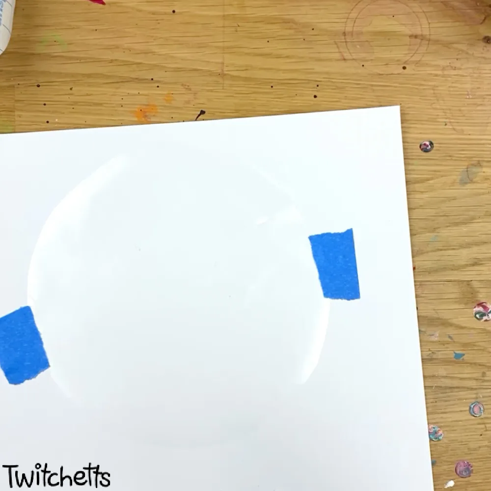 In process image of a paper snow globe craft.