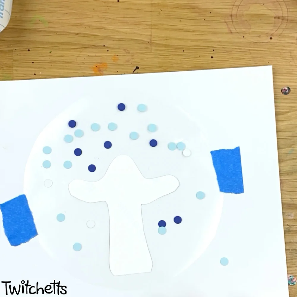 In process image of a paper snow globe craft.